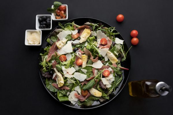 Salade fraîche faites de tomates cerises, olives, pétales de parmesan et émincés de thon